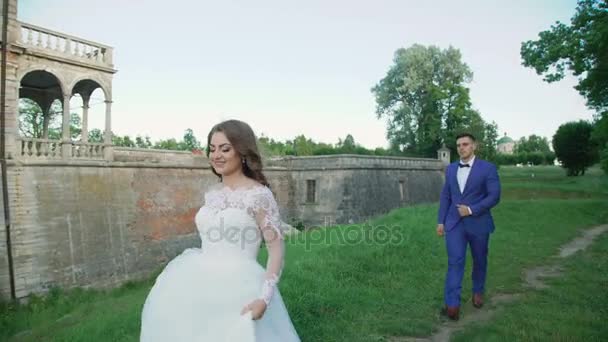 Pareja de bodas camina y posa cerca del antiguo castillo 4K — Vídeos de Stock