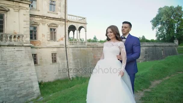 Casamento casal caminha e posa perto do antigo castelo 4K — Vídeo de Stock