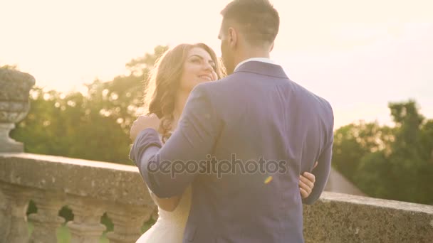 Szczęśliwy ślub para patrząc i obejmując sobą na słoneczny dzień 4k — Wideo stockowe