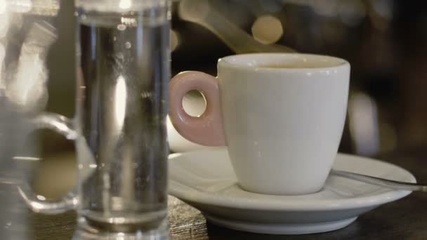 Vy över kopp kaffe och glas vatten på bordet. Långsamt — Stockvideo