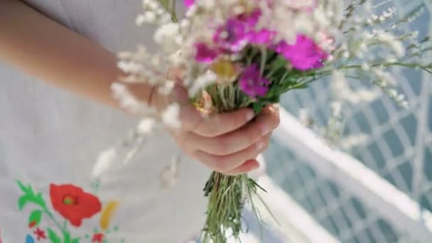 Las manos de las niñas sostienen un ramo de flores en 4K — Vídeo de stock