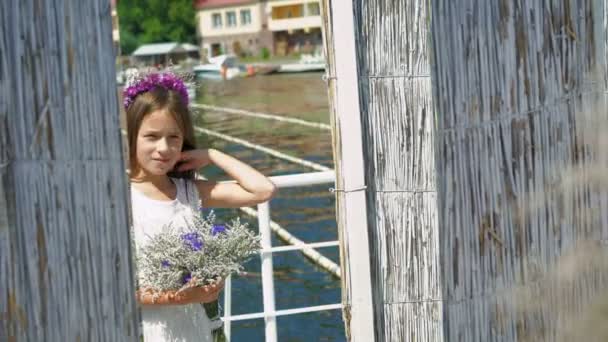 Красивая маленькая кокетка с цветами в руках смотрит в зеркало. 4K — стоковое видео