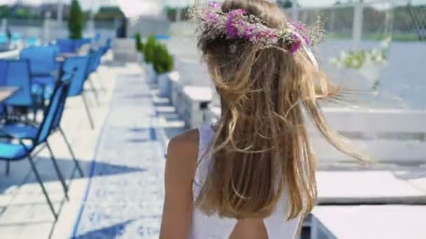 Achteraanzicht van kleine vrouwelijke model wandelingen en spins aan camera 4k — Stockvideo