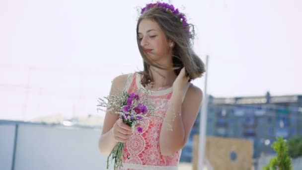 Sorglösa kvinnliga tonåring med bukett blommor ser på blåsiga bay bar 4k — Stockvideo