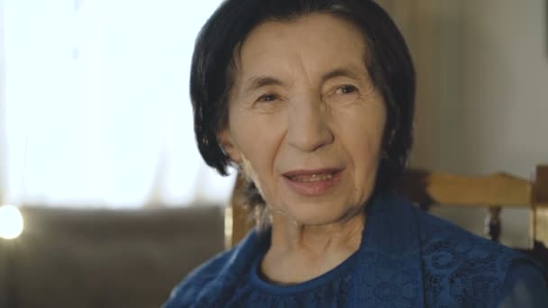 Retrato de anciana feliz en vestido sonriendo a la cámara en la habitación — Vídeo de stock