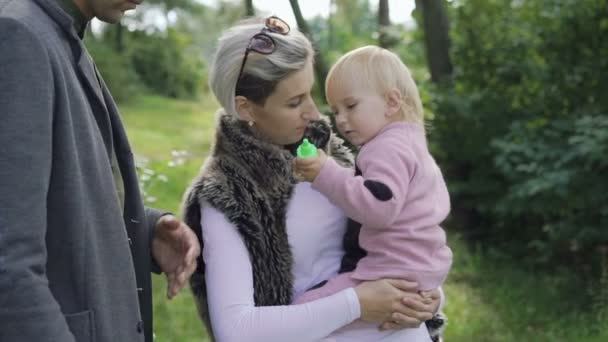 Heureux repos familial sur la nature avec enfant, souffler et attraper des bulles — Video