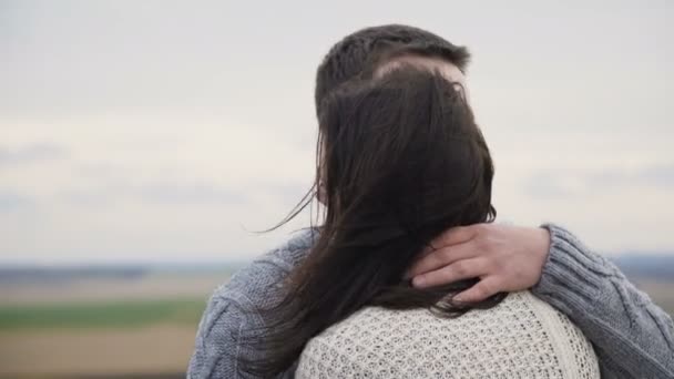 Романтическая пара в объятиях и поцелуях стоит на вершине скалы — стоковое видео