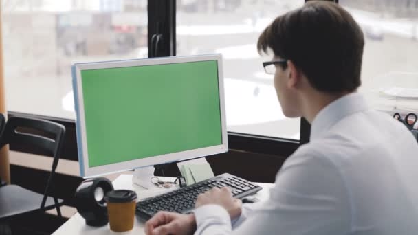 Joven trabaja con PC con pantalla verde y teclado. 4K — Vídeos de Stock