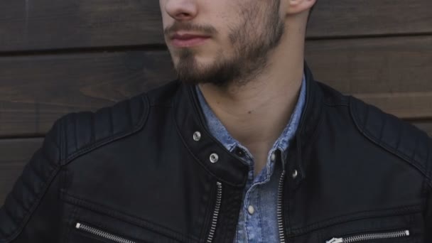 Retrato de un guapo modelo masculino posando en un edificio de madera lentamente — Vídeos de Stock