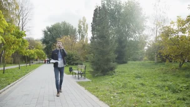 Der Mann telefoniert und wirft Dokumente in einem Park 4k — Stockvideo