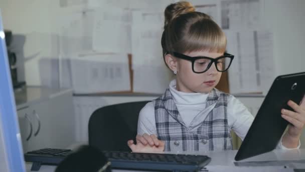 Lindo poco, colegiala inteligente usando PC y tableta en el lugar de trabajo. 4K — Vídeos de Stock