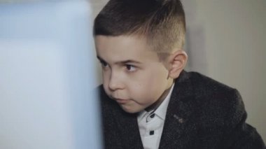 Ciddi yakışıklı meşgul çocuk masasında klavye yazarak