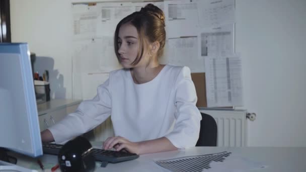 Красивая девушка-подросток в форме с энтузиазмом работает с компьютером. 4K — стоковое видео