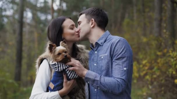 Preciosa pareja se divierten con su perro mascota en el bosque. 4K — Vídeo de stock