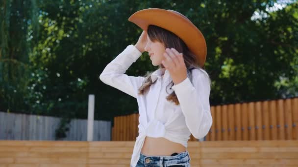 Retrato de menina feliz posa com chapéu na área do cavalo. 4K — Vídeo de Stock