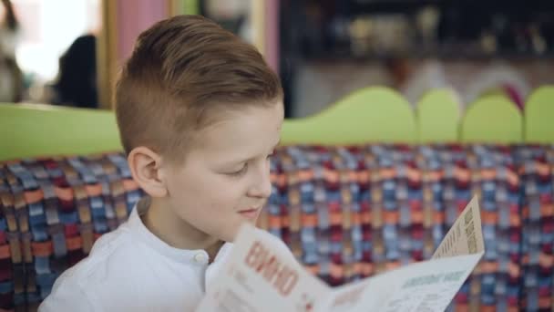 Guapo chico joven leyendo menú en la cafetería. 4K — Vídeos de Stock