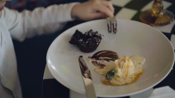 Вид неузнаваемого мальчика, поедающего десерт. 4K — стоковое видео