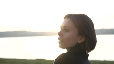 Baştan çıkarıcı kadının portresi kameraya ciddi bir yüzle bakar ve kendinden emin bir şekilde gülümser.