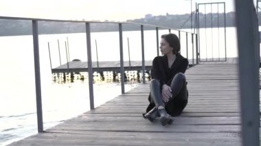 Güzel yalnız kadın güvertede dinleniyor, düşünüyor ve göle bakıyor.