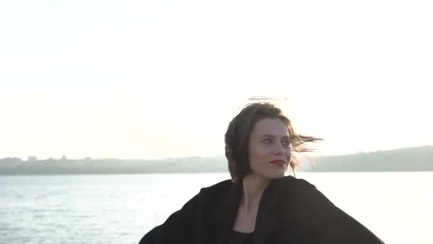 Señora feliz posa y coquetea en la cámara en el lago al atardecer — Vídeos de Stock
