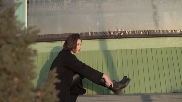 Stílusos lány pihentető utcai padon, és van egy öröm — Stock videók