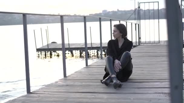 Hermosa mujer solitaria relajándose en la cubierta, pensando y mirando al lago — Vídeos de Stock