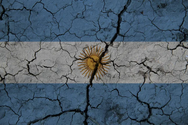 Argentina flag on the background texture of cracked earth. The concept of design solutions.