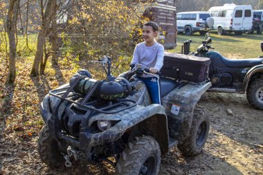 Kız oturur ve ormandaki bir ATV 'ye gülümser..