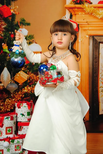 Het Kleine Mooie Meisje Prinses Houdt Haar Handen Een Nieuwjaarsspeeltje Stockafbeelding