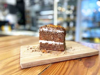 Çikolatalı pasta, kaymak kremalı bir parça pasta ve tahta üzerinde havuç. Kafe Biçimi Konsepti