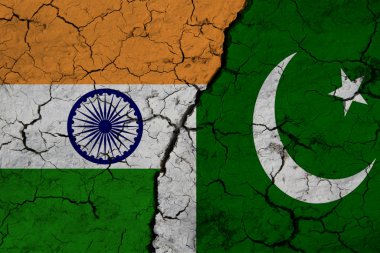 Hindistan bayrağının ve Pakistan bayrağının yakın plan görüntüsü çatlak dünyanın arka planına karşı. Savaş krizi kavramı ve Hindistan ile Pakistan arasındaki çatışma..