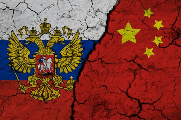ロシア連邦の国旗と中国の国旗が地殻変動を背景にクローズアップされています ロシアと中国の関税貿易戦争の危機の概念 — ストック写真