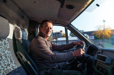 Bir adam modern bir kamyonun taksisinde oturuyor..