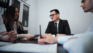 Modern bir ofisteki bir grup iş adamı fikir üreten ve iş planı hazırlayan iş adamları. İş adamları bir planlama toplantısında masada oturuyorlar. İş konsepti.