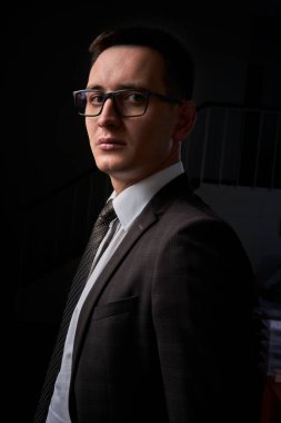 Genç bir adamın yakın plan portresi, mutlu, neşeli, yakışıklı iş adamı modern ofiste beyaz gömlekle duruyor.