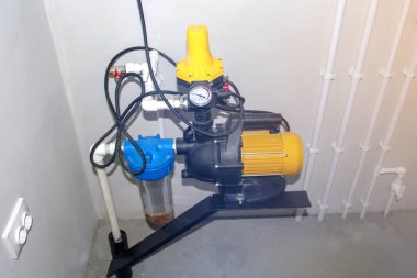 Pompa odasında beyaz bir duvara karşı bir su pompası için motor