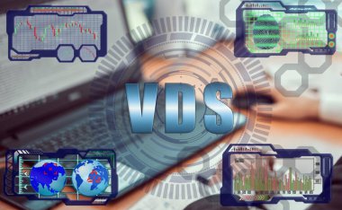 Hands of a businessman using a laptop with smart phone and futuristic holographic screen in the graphs of the exchange rate and the inscription: VDS. Virtual Dedicated Server concept. clipart