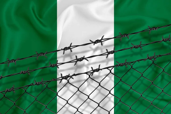 ナイジェリア国旗 メッシュフェンス 鉄条網の開発 移民の隔離という概念 テキストの代わりに — ストック写真