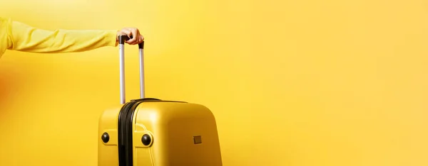 Woman holding yellow suitcase in hand — Stock Photo, Image