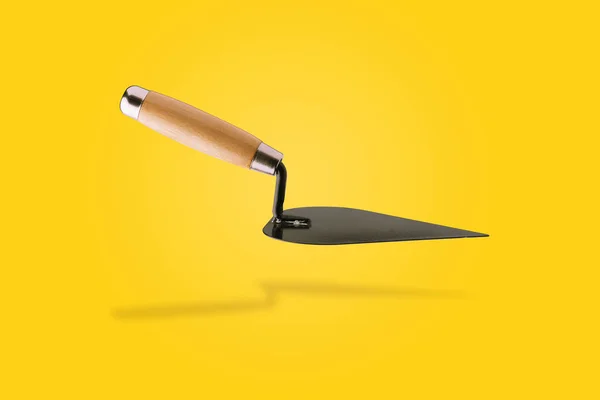 Triangle trowel over yellow — Stock Photo, Image