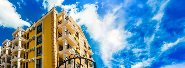 美しい雲と青空を背景にした豪華なオレンジホテル テキストのためのスペースを持つパノラマ画像 — ストック写真