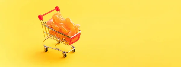 Sarı Arka Planda Bir Alışveriş Arabasında Mandalinalar Sağlıklı Gıda Konsepti — Stok fotoğraf