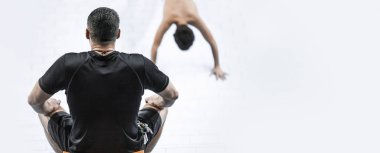 Kişisel antrenör, arkadan görüntü, atletlerini izliyor.