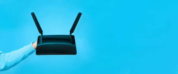Czarny Router Wifi Rękę Niebieskim Tle — Zdjęcie stockowe