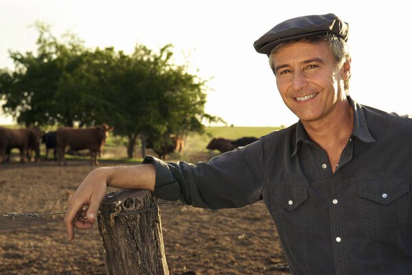 senior man standing near wooden fence 