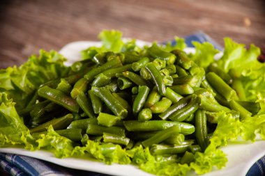 Keten bir havlu ve bir ahşap backg beyaz bir tabağa yeşil fasulye