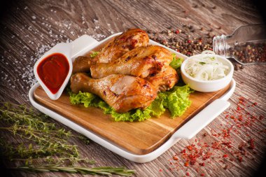 Beyaz Kupası ile ve çevresinde bir ahşap tahta üzerinde ızgara tavuk budu