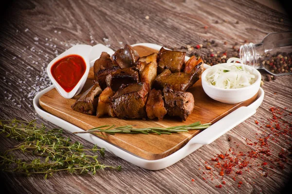 Skewers of liver on a wooden board with white cup and around the — Stock Photo, Image