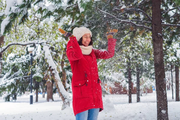 Девушка, стоящая под веткой дерева, которой можно высыпать снег — стоковое фото