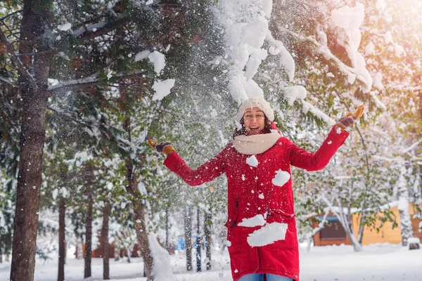Девочка находится под снегом, который льется с дерева — стоковое фото